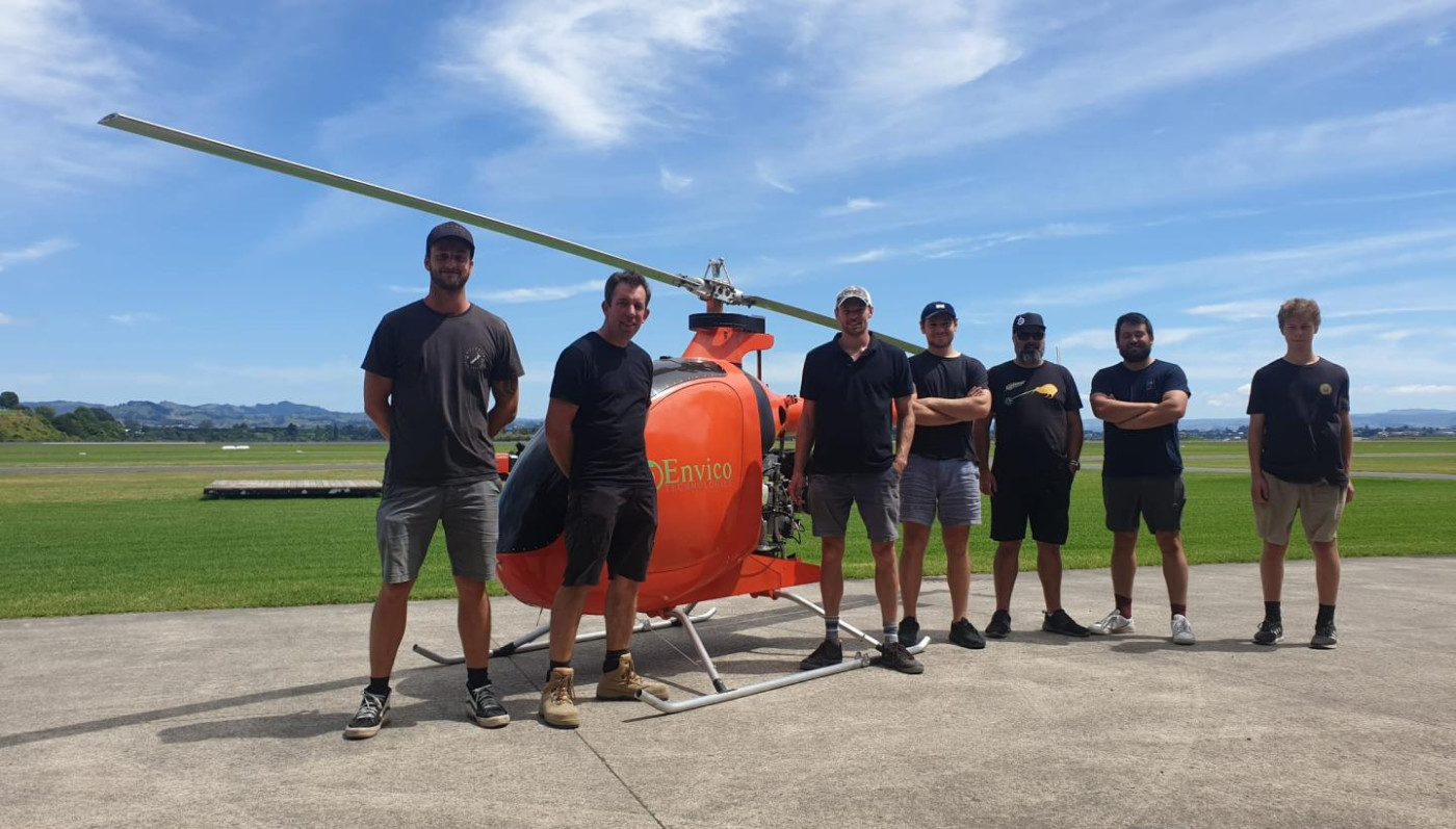 The team at Envico Technologies standing infront of their helicopter